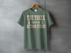 Green t-shirt with cream text reading "THE TREES HAVE NO ACTION ITEMS" and two tree icons.