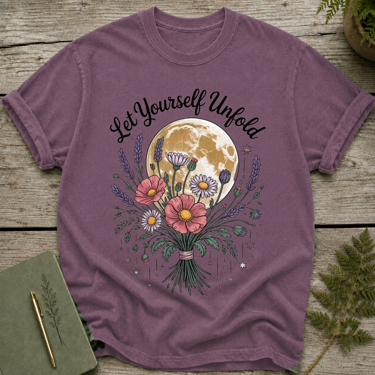 Purple t-shirt with a bouquet of flowers and the moon. "Let Yourself Unfold" text.