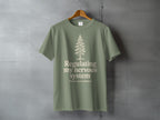 Sage green t-shirt with a minimalist pine tree and "Regulating my nervous system poorly, but outdoors" text.