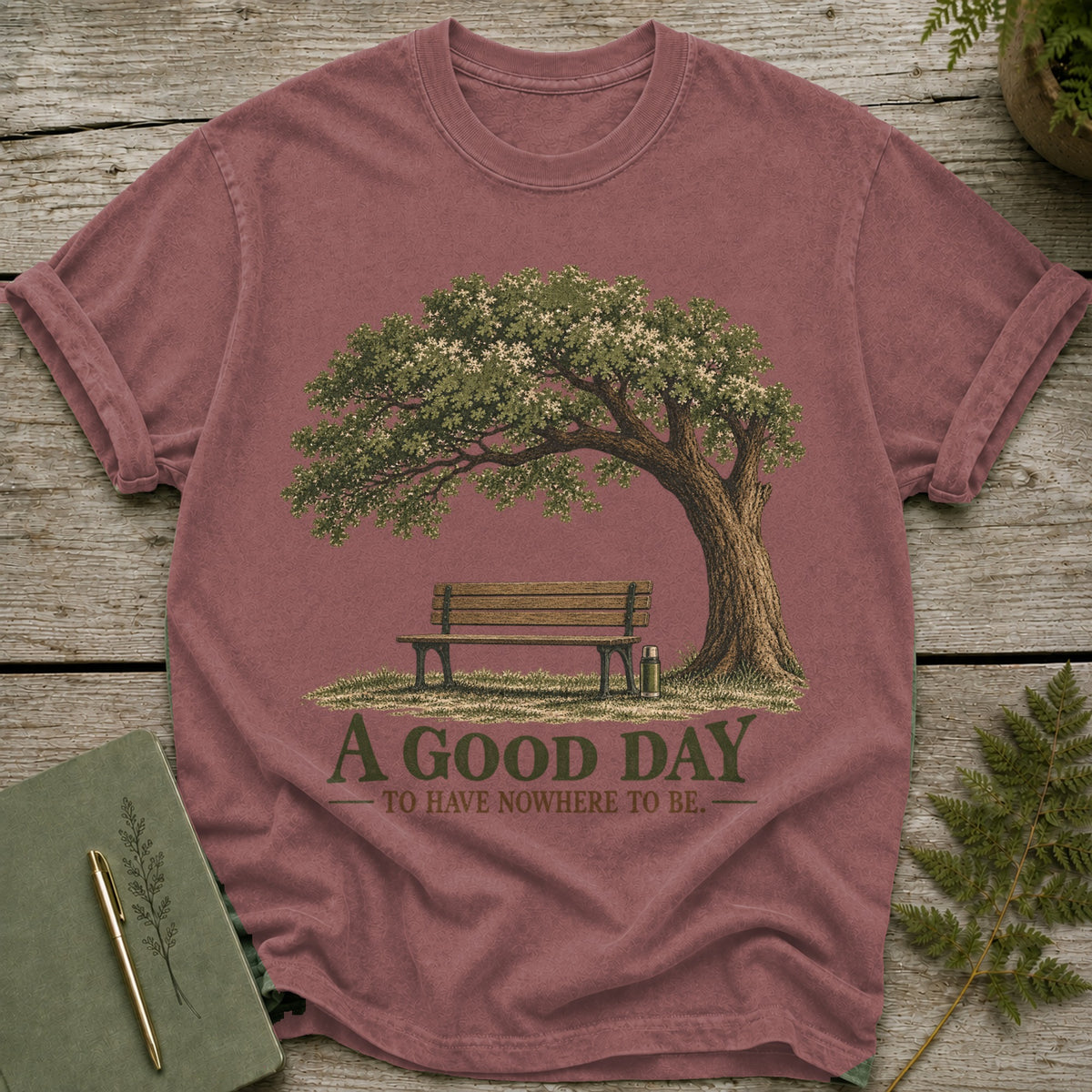 T-shirt with graphic of park bench under tree and text "A GOOD DAY TO HAVE NOWHERE TO BE."