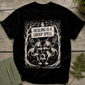 Black t-shirt with "HEALING IS A GROUP SPELL" and witches around a crystal ball.