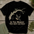 Black t-shirt with a bird flying by a branch graphic and text.