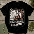 Black t-shirt with a wolf in monk robes holding a coffee cup under a tree, text "Decaf? No Thanks I Meditate".