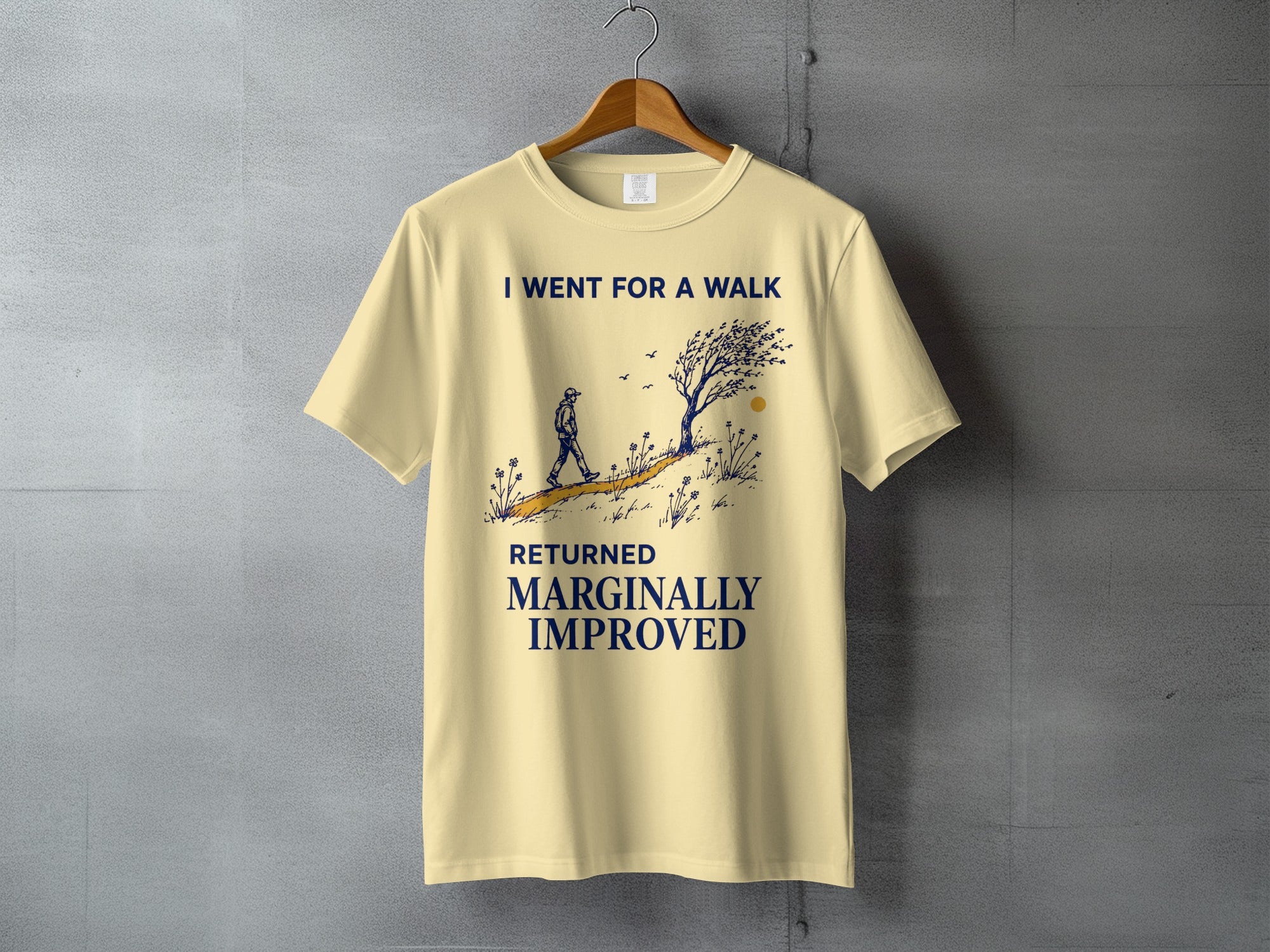 Cream t-shirt with a graphic of a person walking and text that reads "I WENT FOR A WALK RETURNED MARGINALLY IMPROVED."