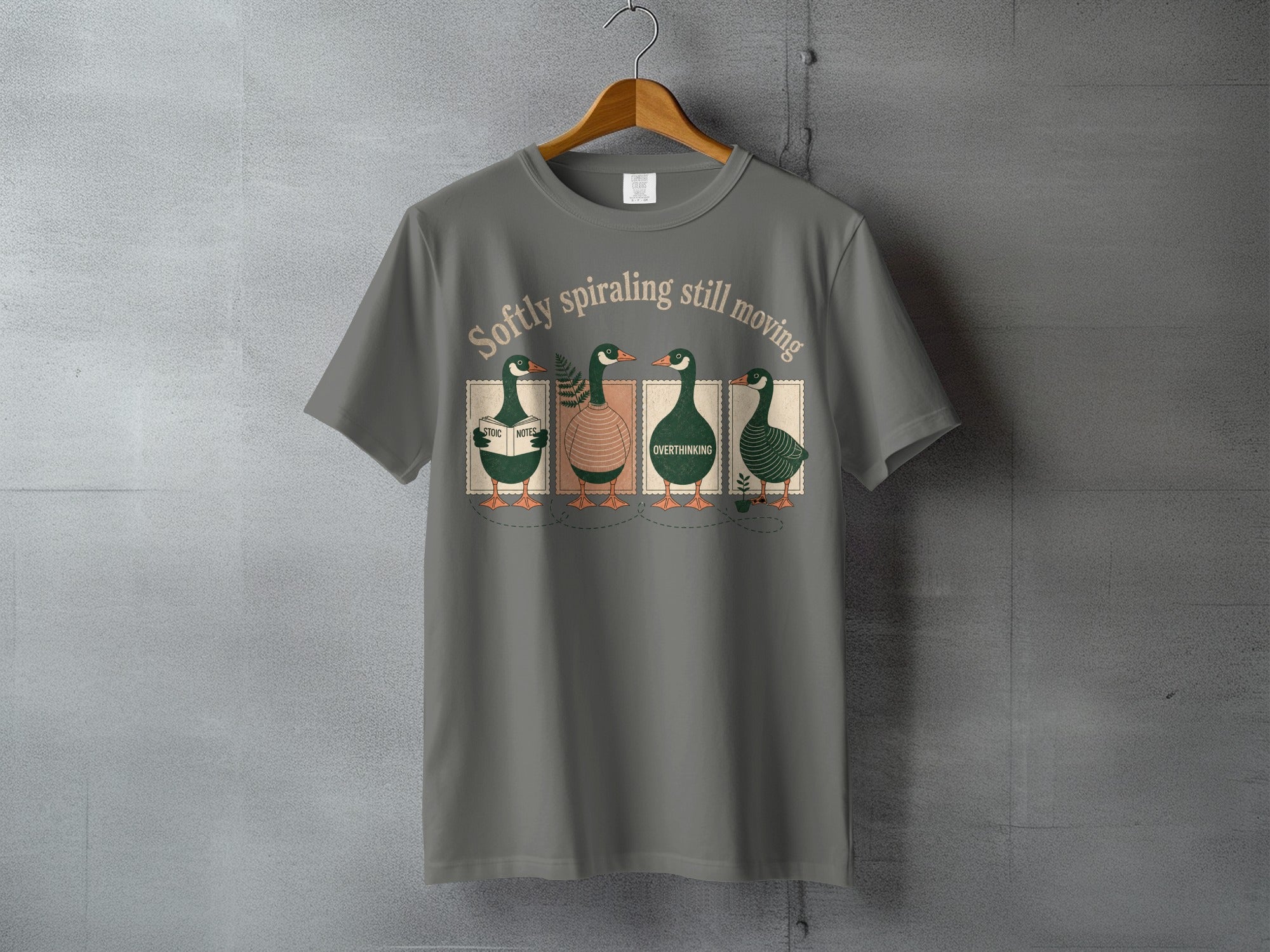 Gray t-shirt with four ducks reading, "Softly spiraling still moving."