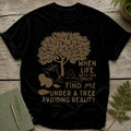 Black t-shirt with graphic of person under tree and text "When life gets too much find me under a tree avoiding reality".