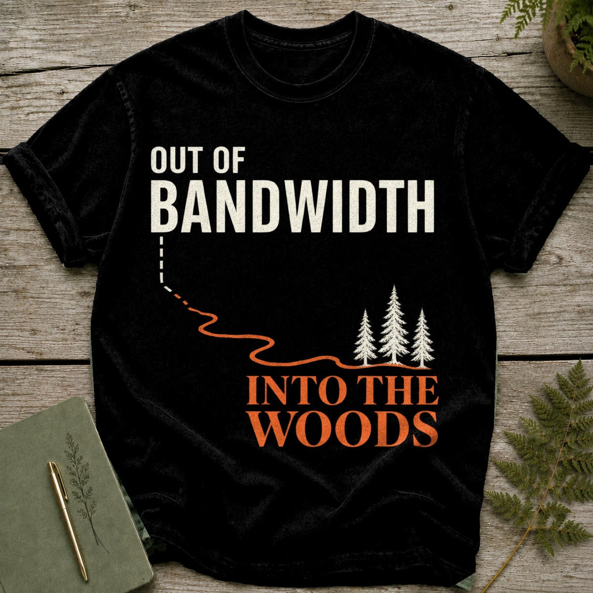 Black t-shirt with "Out of Bandwidth, Into the Woods" text and pine trees graphic.