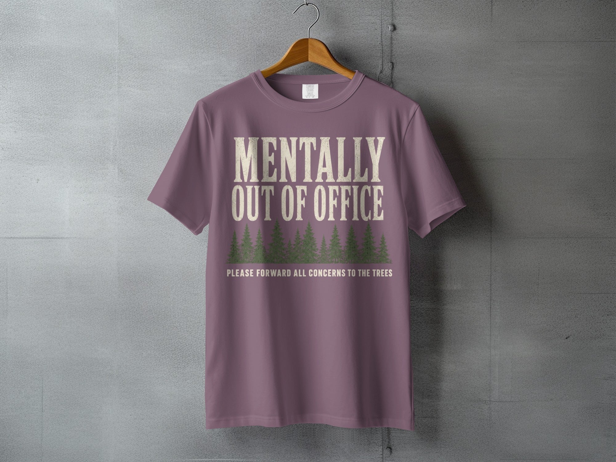 Purple t-shirt with "Mentally Out Of Office" and forest graphic.