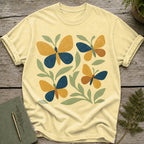 Light yellow t-shirt with abstract butterfly and leaf pattern in blue, gold, and rust.