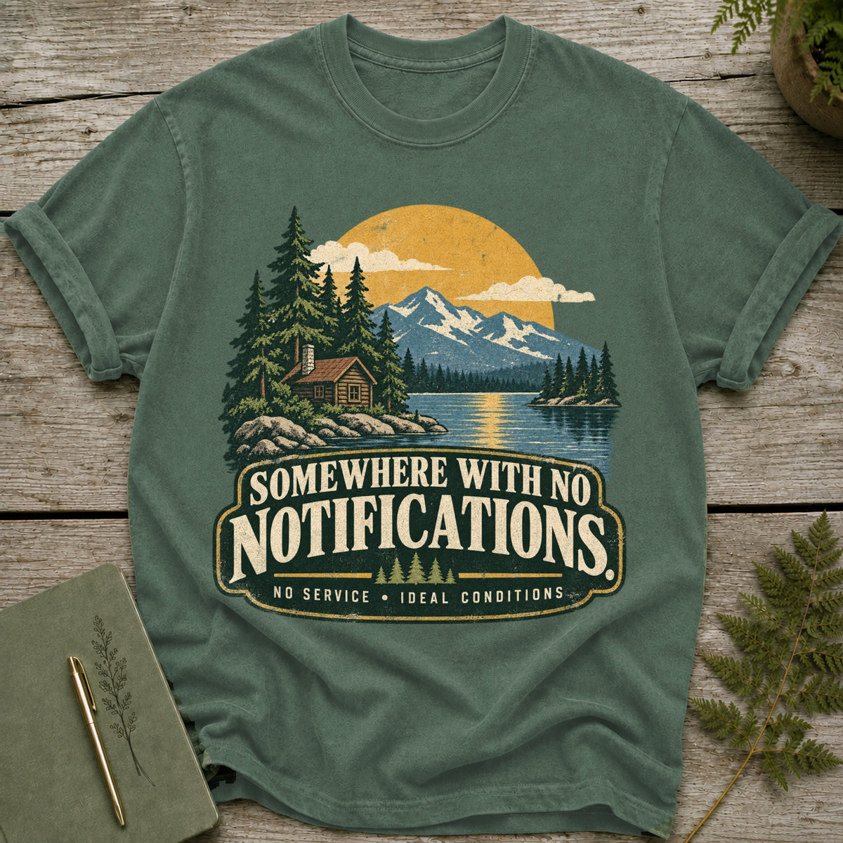Green t-shirt with "Somewhere With No Notifications" graphic and outdoor scene.