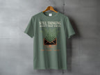 Green t-shirt with text "Still thinking about that email ten years later" and a fern.