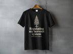 Black t-shirt with a pine tree and "Regulating my nervous system poorly, but outdoors" text.