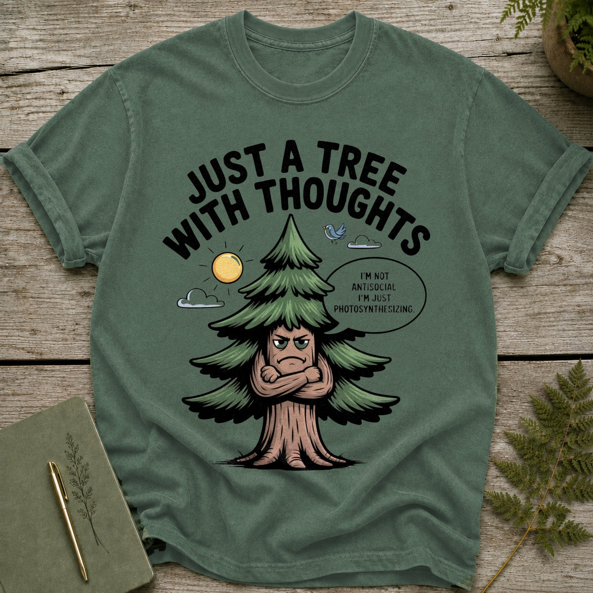 Green t-shirt with a cartoon tree with arms crossed and the text "Just a tree with thoughts".