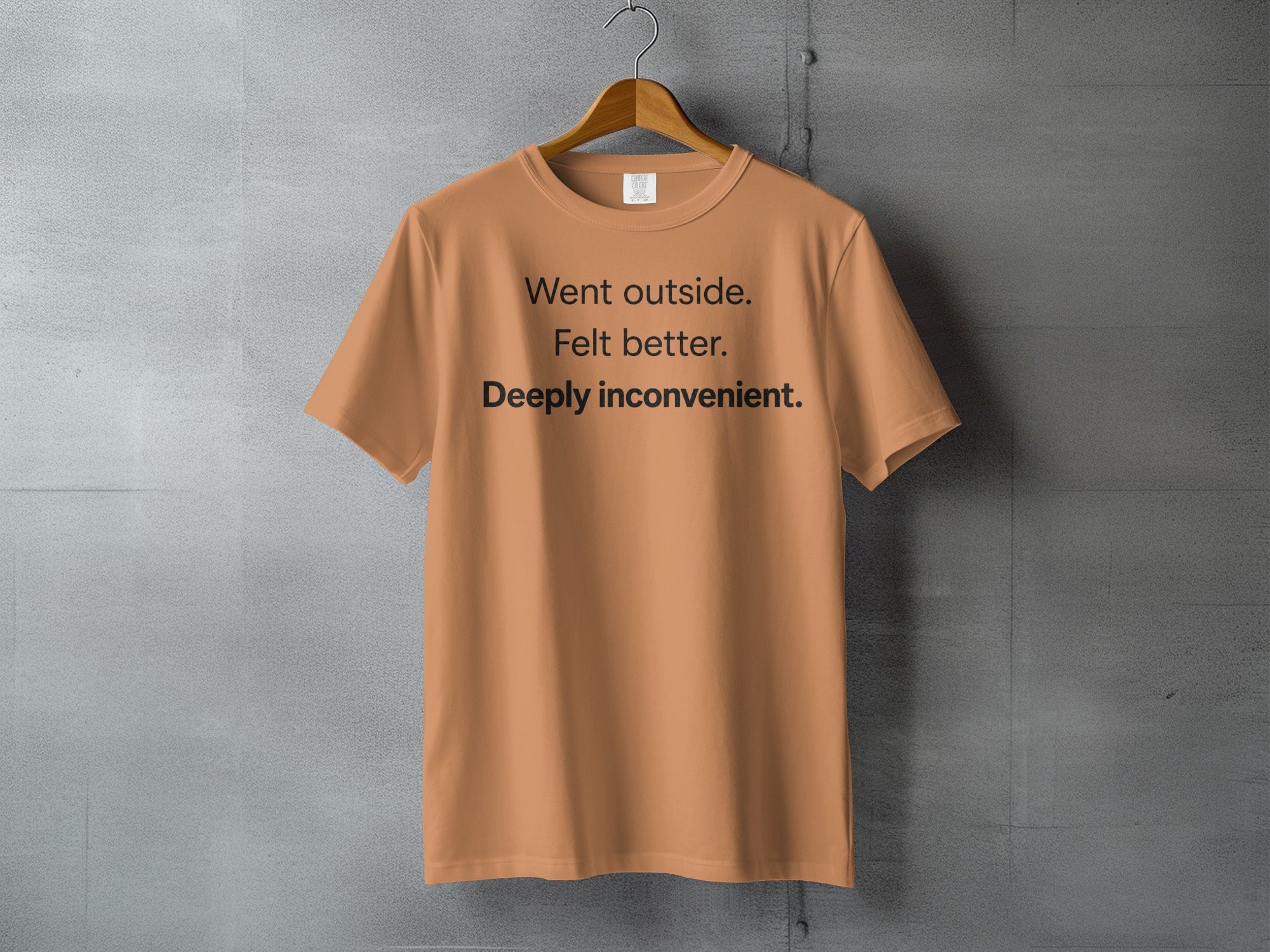 Orange t-shirt with black text reading "Went outside. Felt better. Deeply inconvenient."