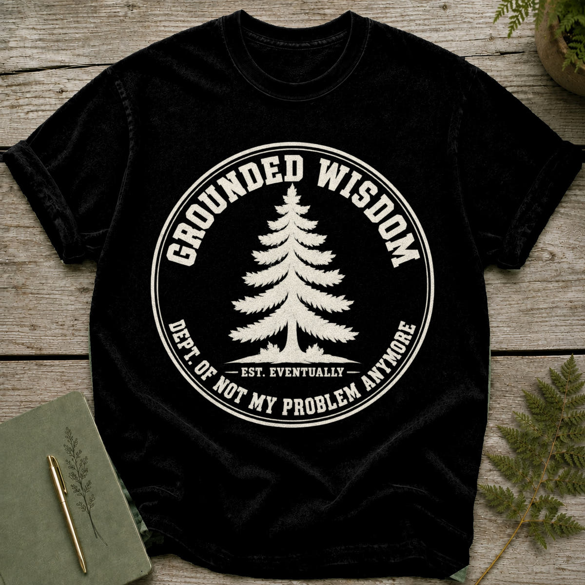 Black t-shirt with "Grounded Wisdom" text, tree graphic, and "Dept. of Not My Problem Anymore" saying.