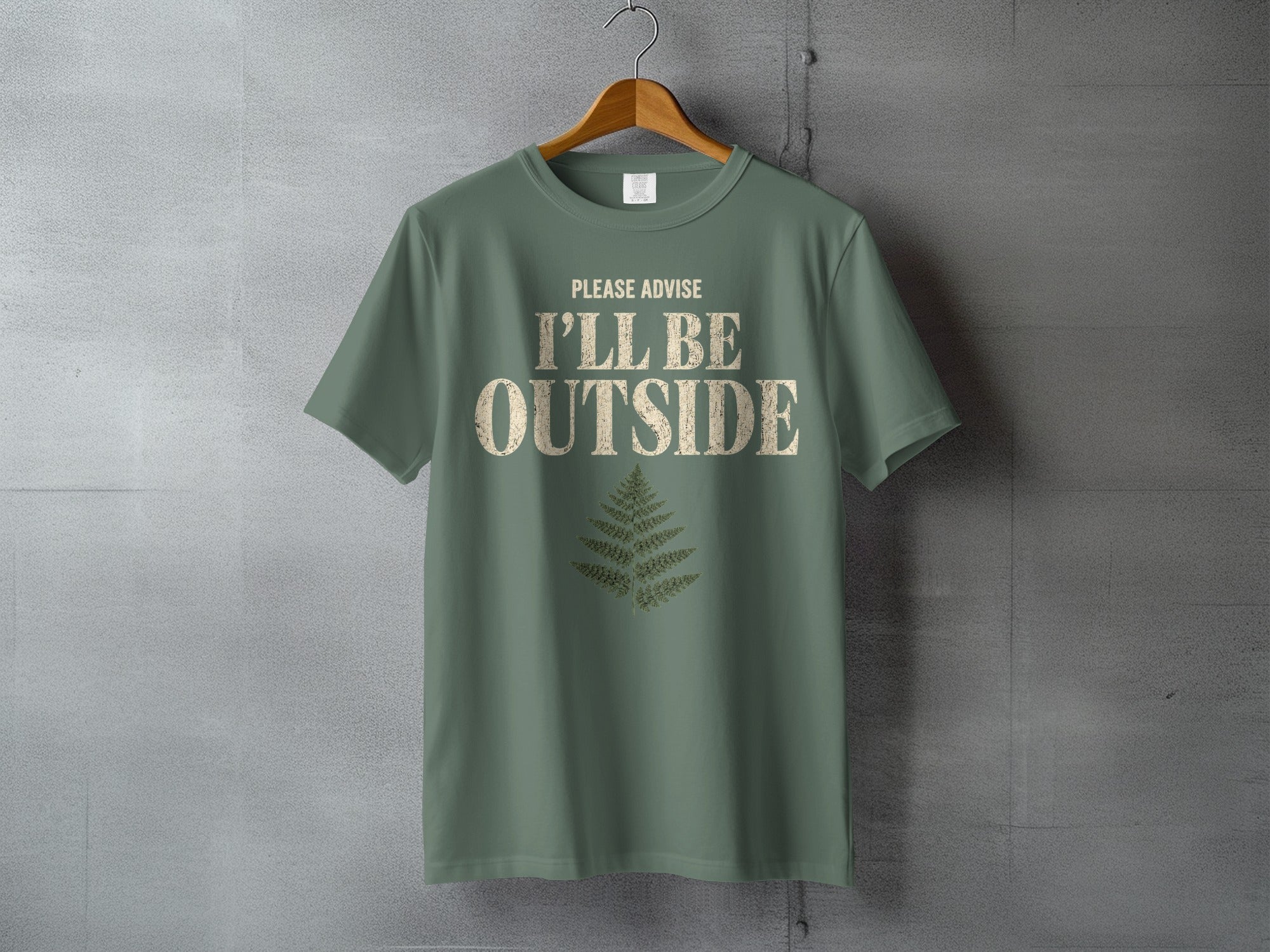 Green t-shirt with "PLEASE ADVISE I'LL BE OUTSIDE" text and fern graphic.