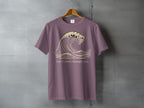 Purple t-shirt with a graphic of a breaking wave and the text "Let it move through you."