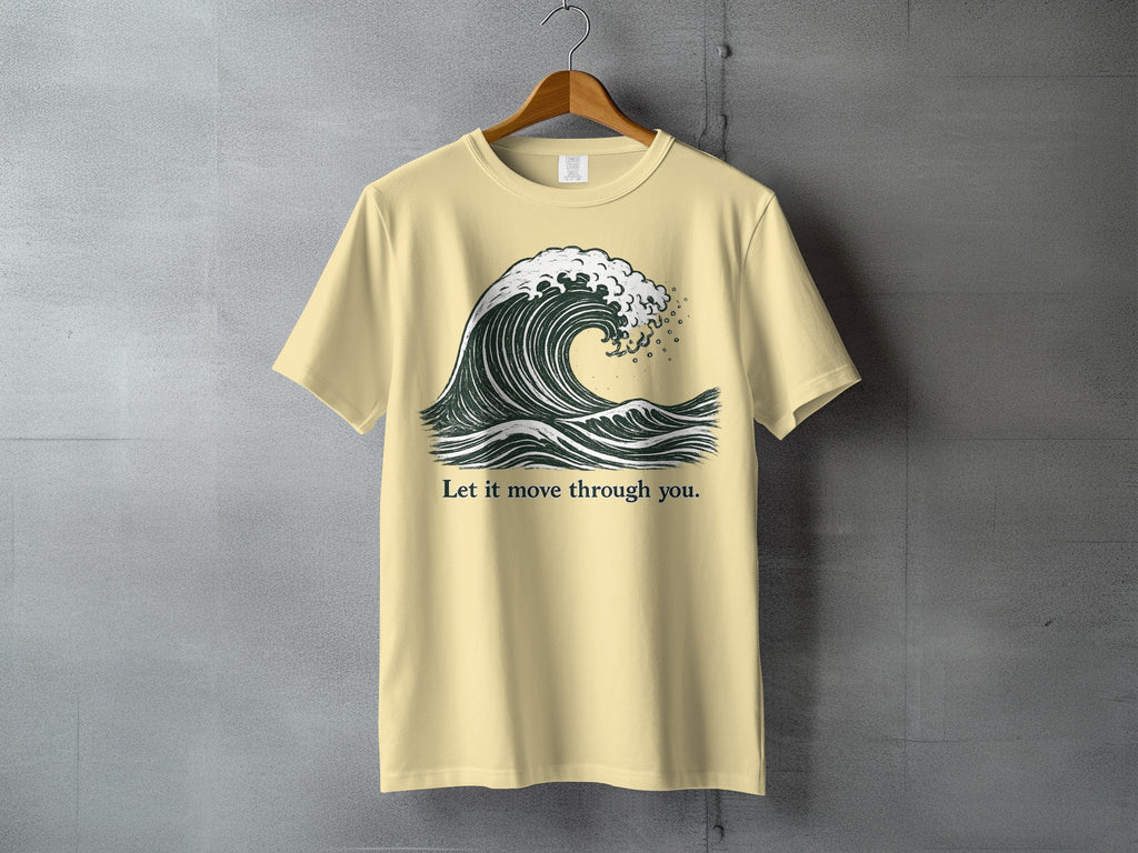 Light yellow t-shirt with a dark green wave graphic and text "Let it move through you."