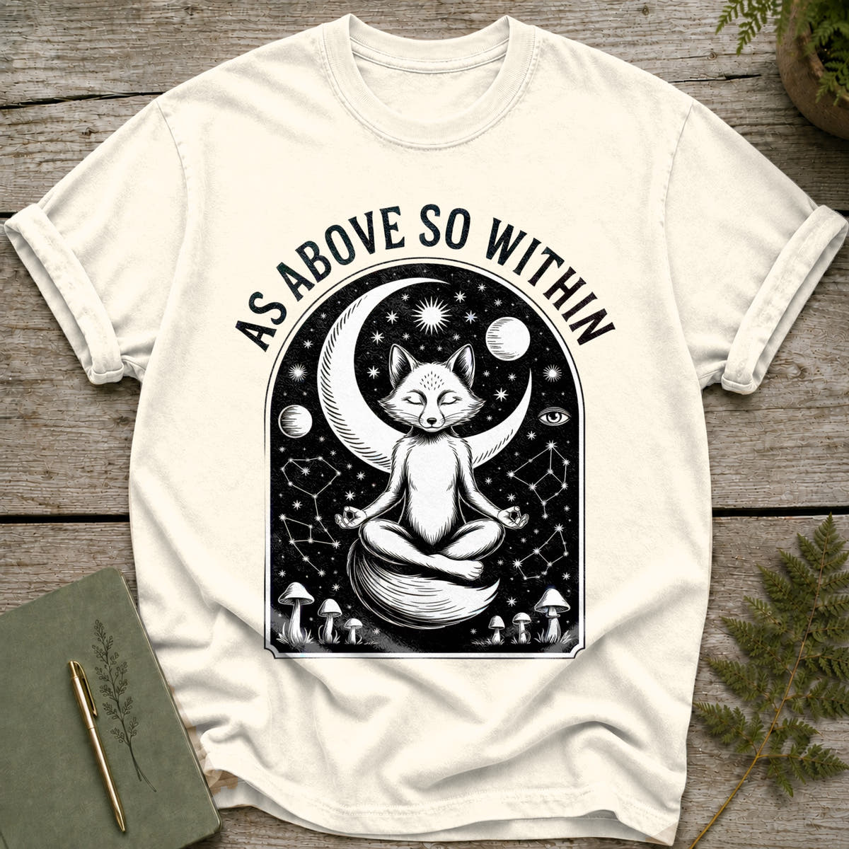 White t-shirt with a black graphic of a meditating fox, moon, stars, and mushrooms. Text reads "AS ABOVE SO WITHIN."