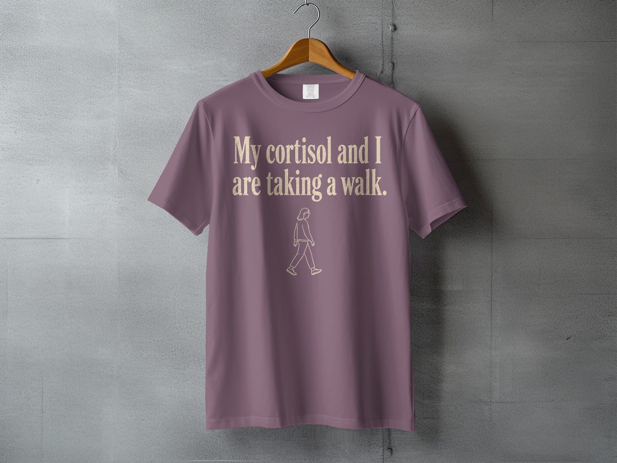 Mauve t-shirt with text "My cortisol and I are taking a walk." and a walking figure.