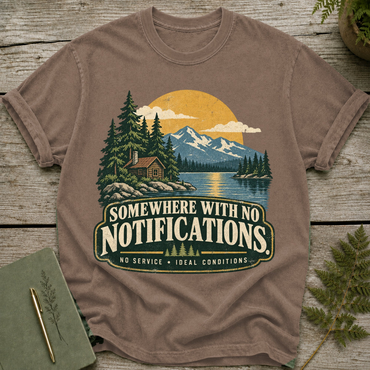 T-shirt graphic with cabin, lake, mountains, and text "Somewhere with no notifications."