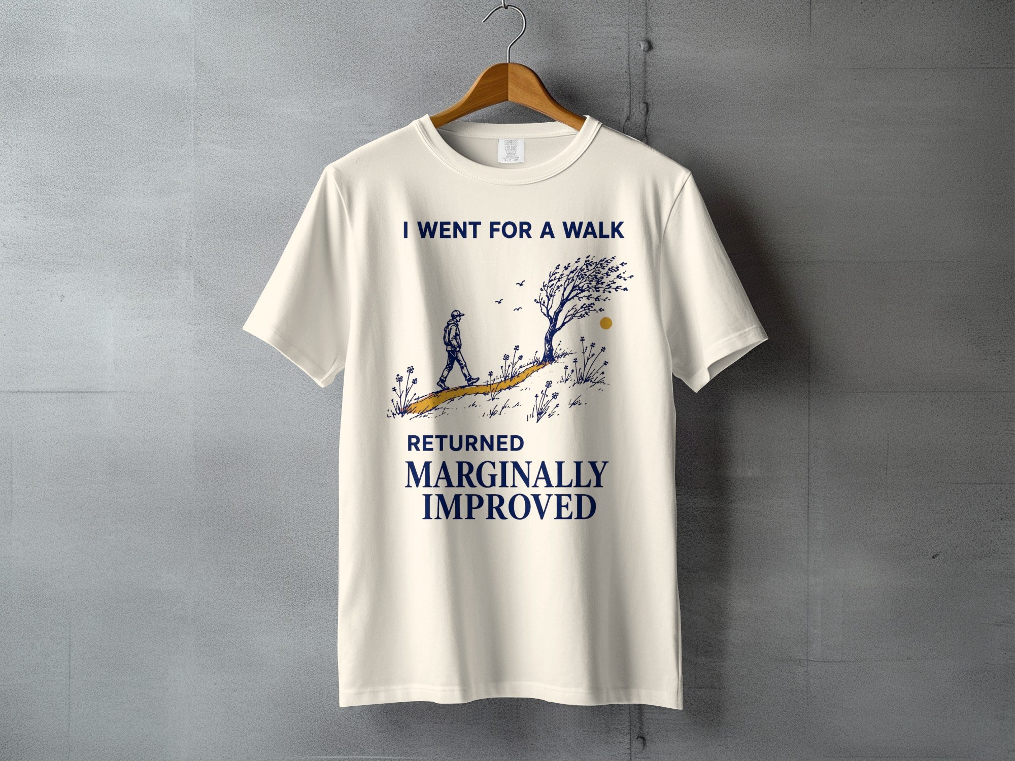 Cream t-shirt with navy graphic and text "I WENT FOR A WALK RETURNED MARGINALLY IMPROVED."