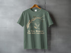 Green t-shirt with a drawing of a bird on a branch and text.