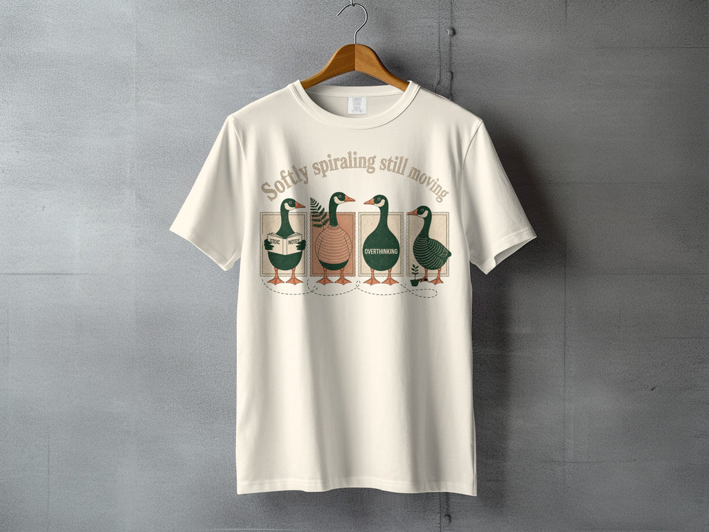 Four cartoon ducks wearing hats on a t-shirt reading "Softly spiraling still moving".