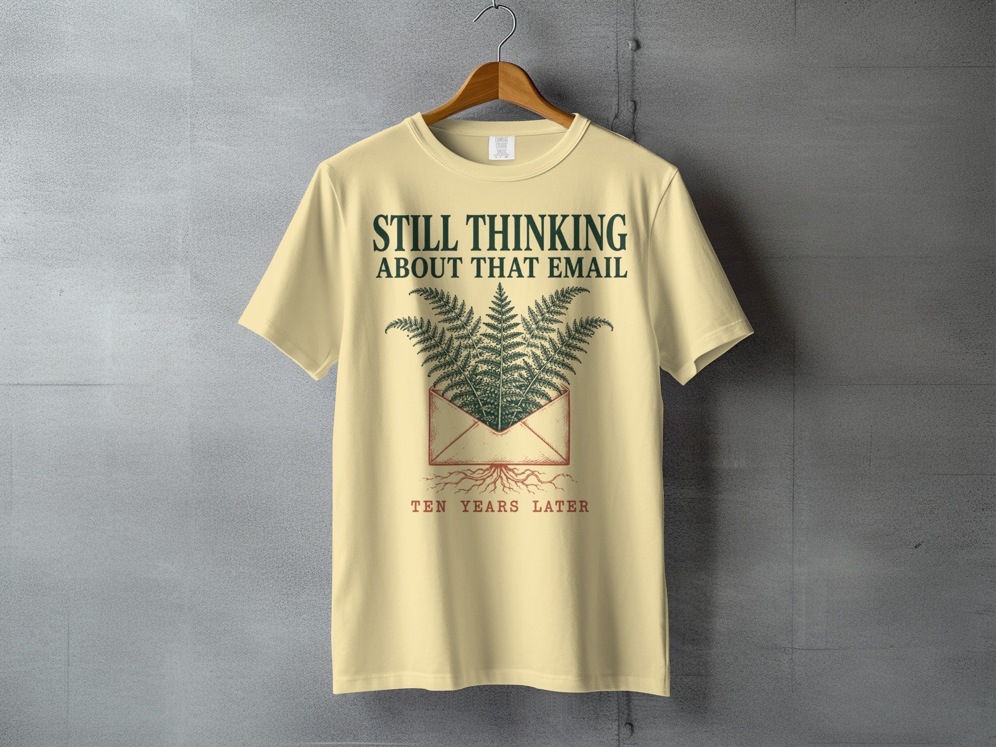 Light yellow t-shirt with "Still Thinking About That Email" and ferns.