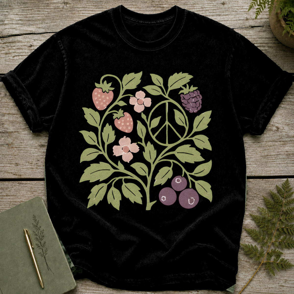 Black t-shirt with a floral design featuring strawberries, berries, flowers, and a peace sign.