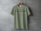 Olive green t-shirt with "A quiet walk for a loud mind" text and a curved line.