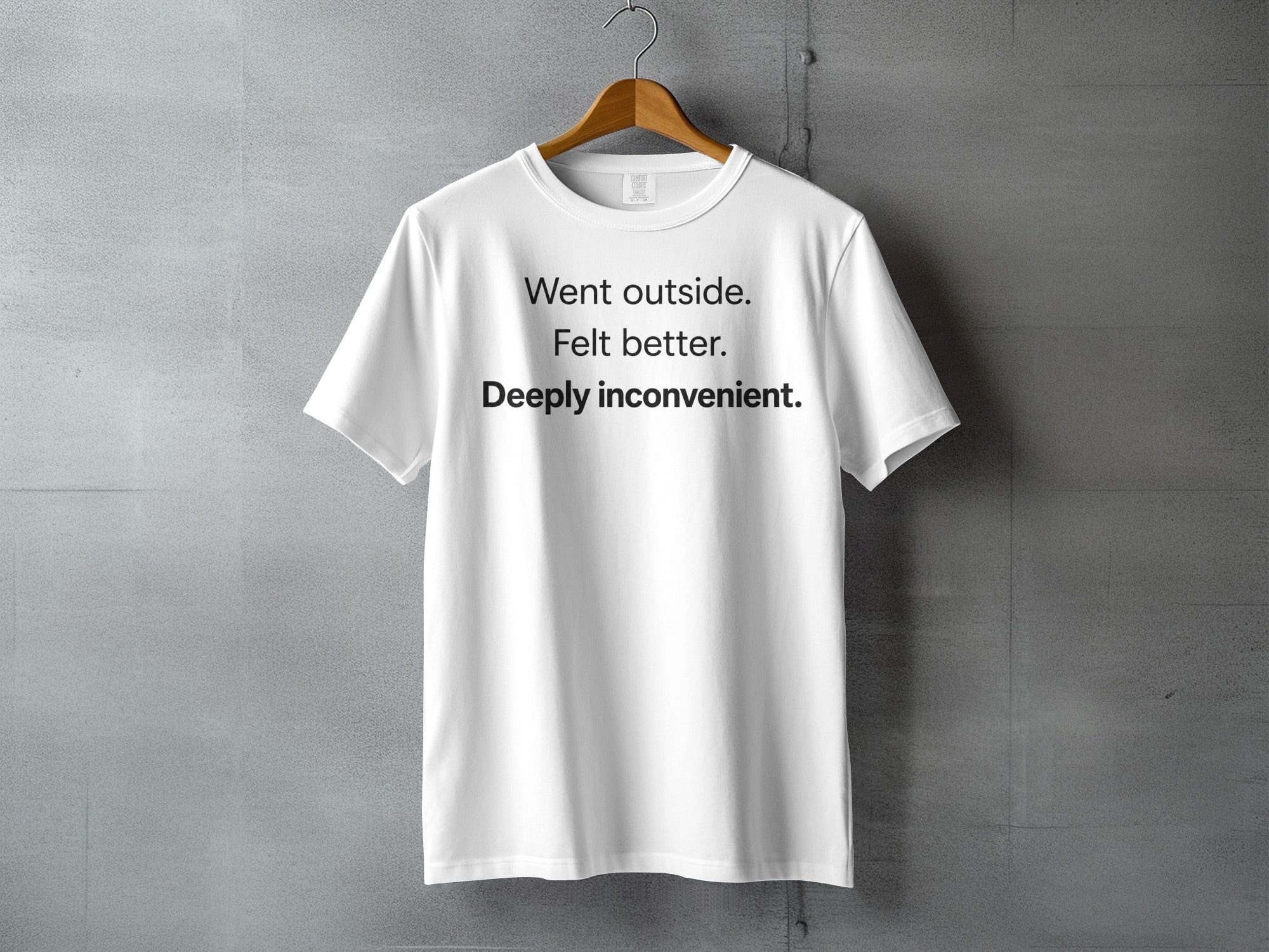 White t-shirt with "Went outside. Felt better. Deeply inconvenient." printed on the front.