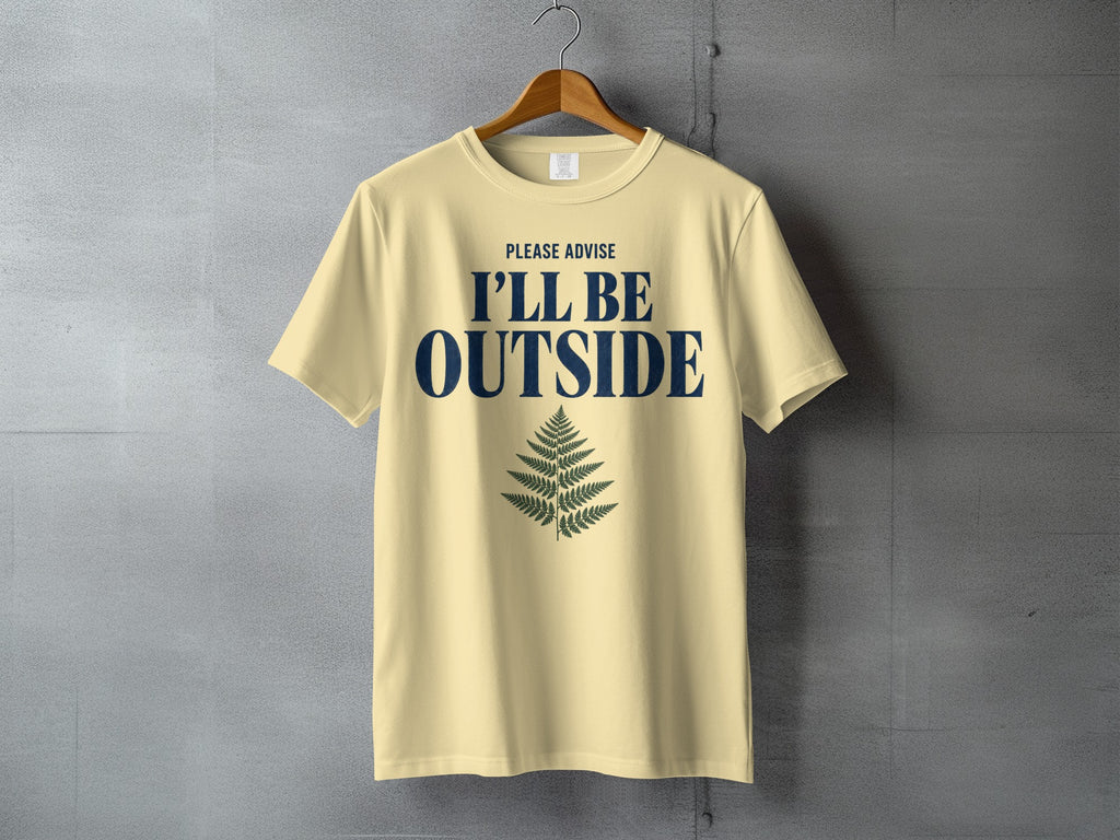 Light yellow t-shirt with navy text "PLEASE ADVISE I'LL BE OUTSIDE" and a fern graphic.