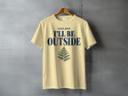 Light yellow t-shirt with navy text "PLEASE ADVISE I'LL BE OUTSIDE" and a fern graphic.
