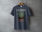 Dark grey t-shirt with text "STILL THINKING ABOUT THAT EMAIL TEN YEARS LATER".
