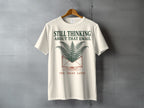 Cream t-shirt with "STILL THINKING ABOUT THAT EMAIL TEN YEARS LATER" and fern graphic.