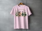 Pink t-shirt with four illustrated ducks reading and writing.