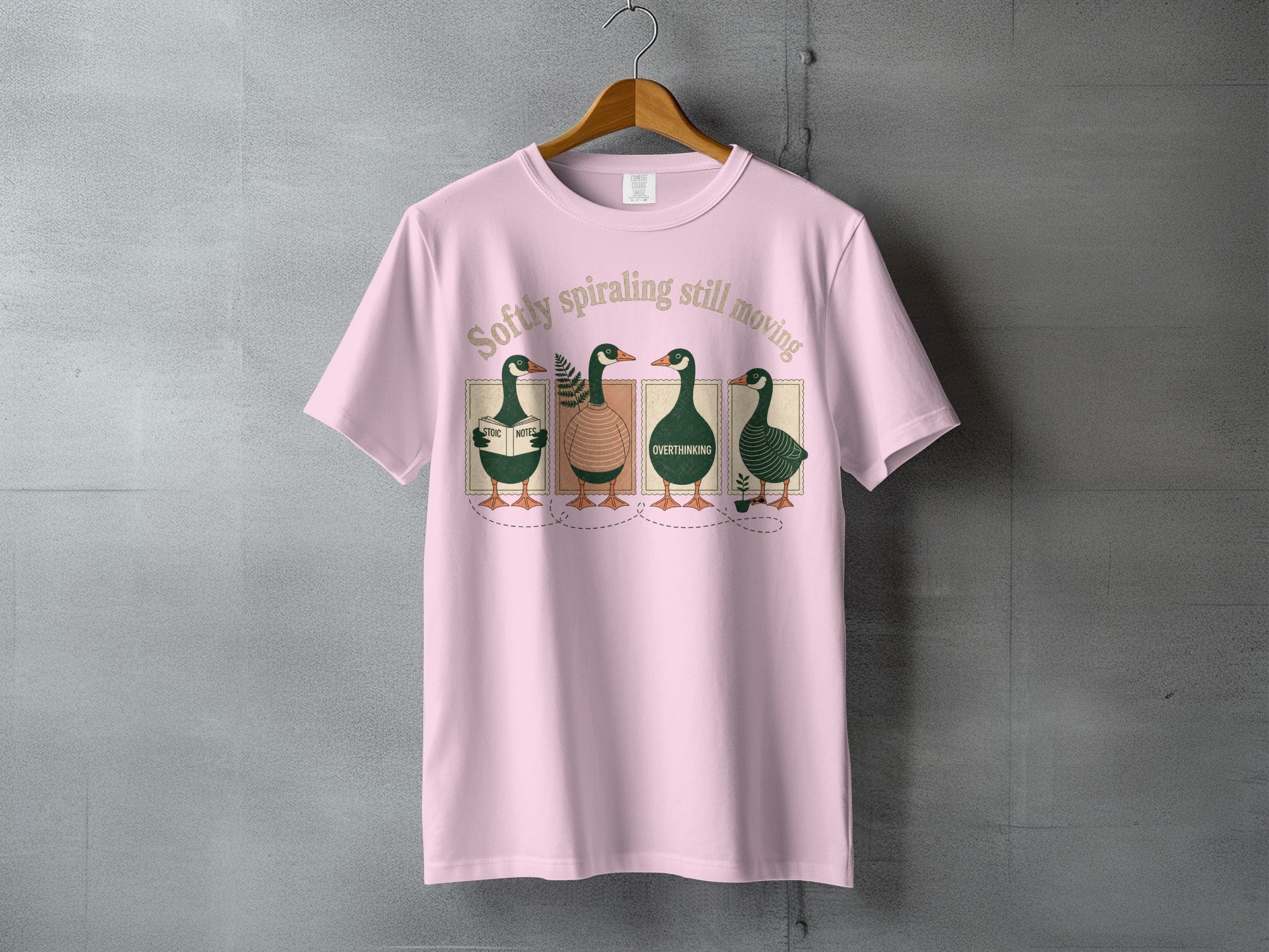 Pink t-shirt with four illustrated ducks reading and writing.
