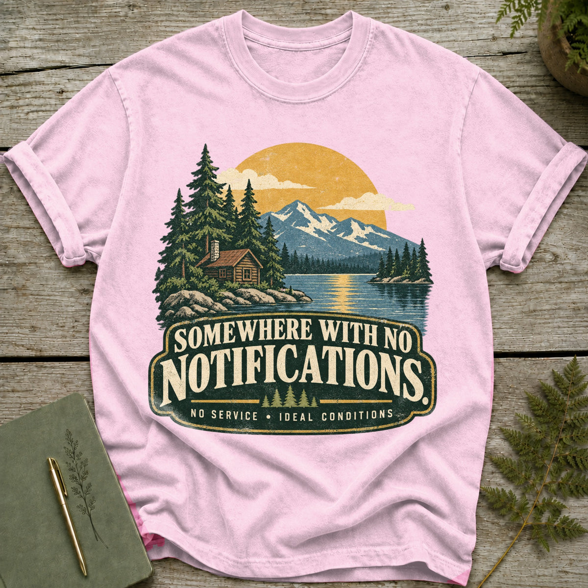 Pink t-shirt with "Somewhere with no notifications" graphic and mountain lake scene.