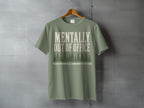 Green t-shirt with "MENTALLY OUT OF OFFICE" and trees graphic.