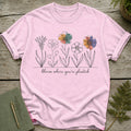 Pink t-shirt with line drawing of flowers and the text "bloom where you're planted".