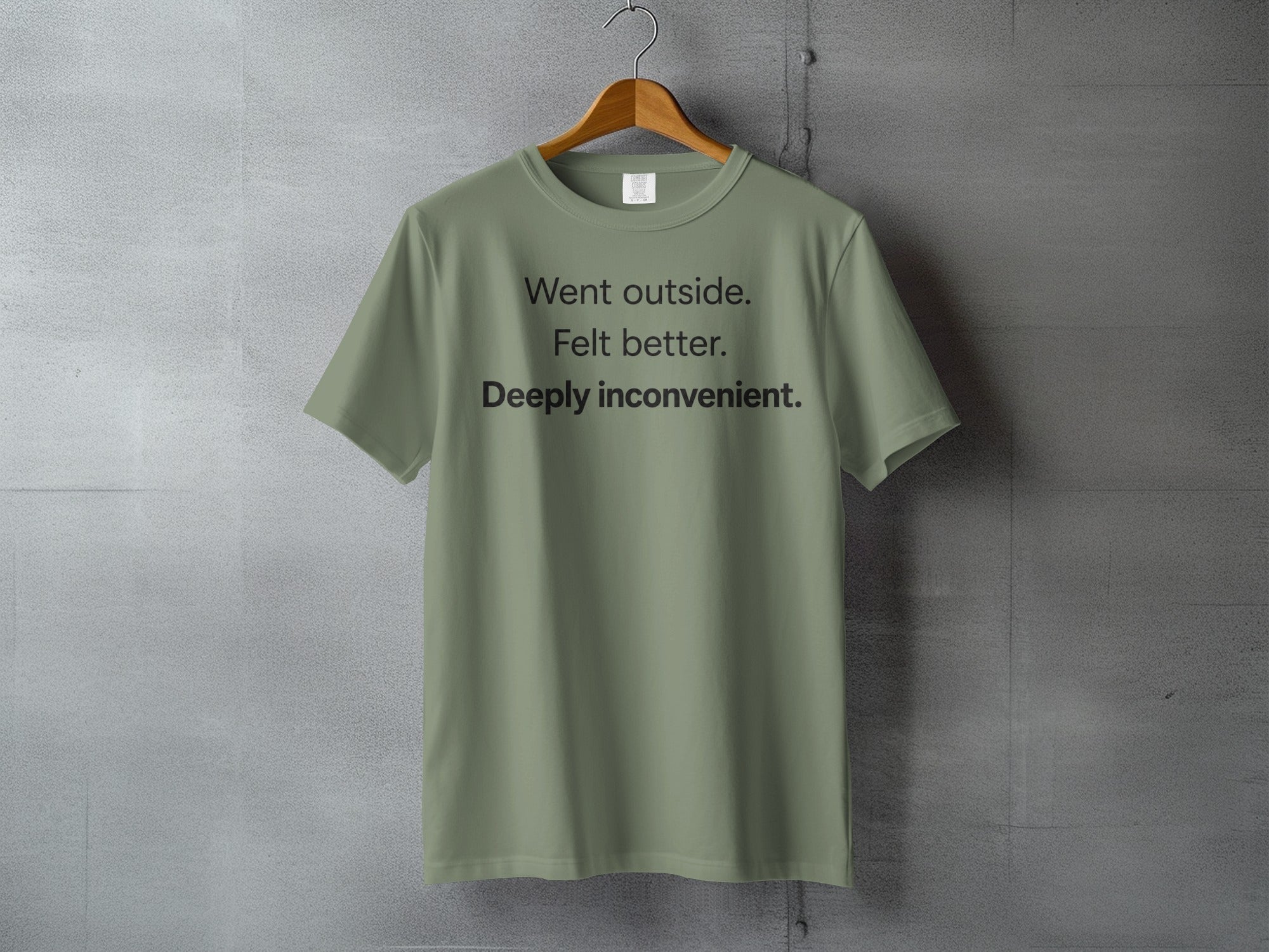 Olive green t-shirt with "Went outside. Felt better. Deeply inconvenient." printed on it.