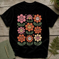 Black t-shirt with a grid of smiling, retro-style flowers in pink, orange, and yellow.