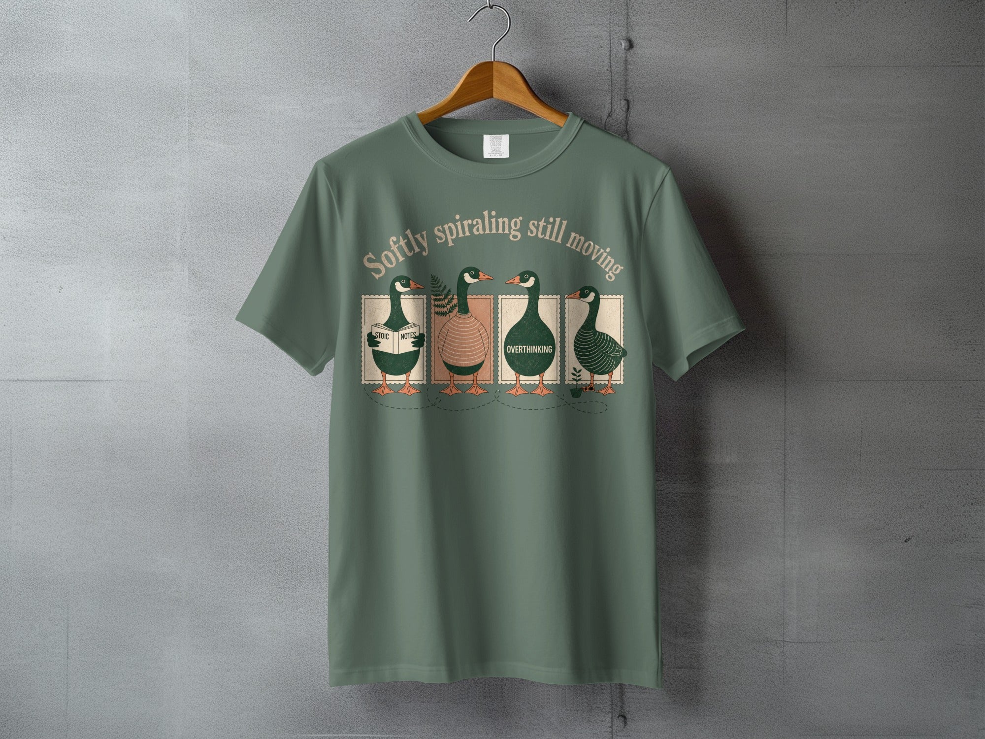Four ducks with books labeled "music," "notes," and "overthinking" on a green t-shirt.