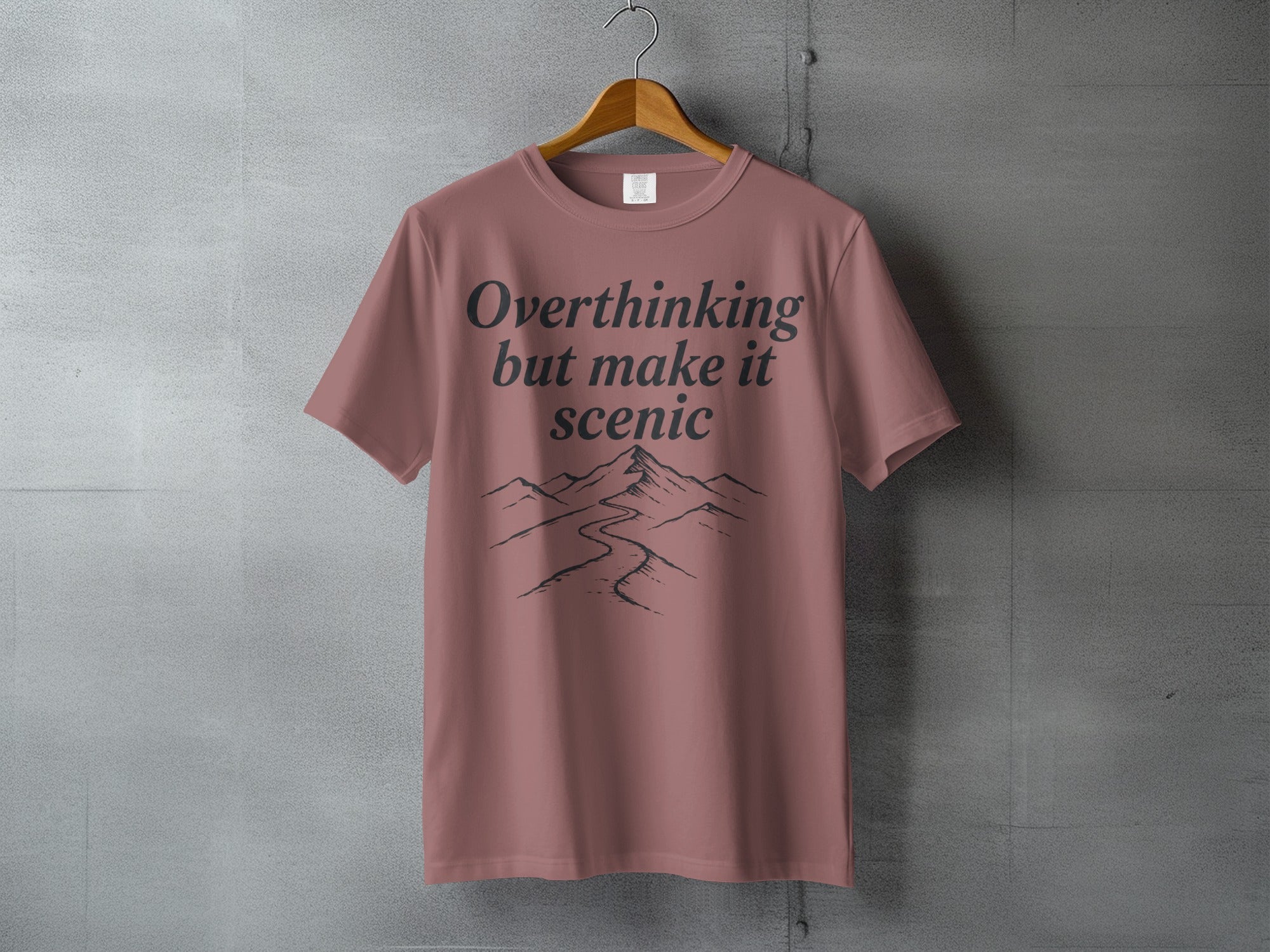 T-shirt with "Overthinking but make it scenic" text and mountain landscape graphic.