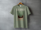 Light green t-shirt with text "STILL THINKING ABOUT THAT EMAIL" and fern imagery.