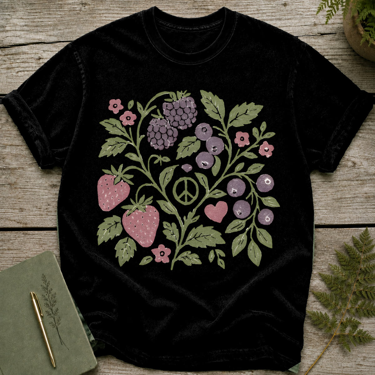 Black t-shirt with a black graphic featuring berries, strawberries, flowers, and a peace sign.