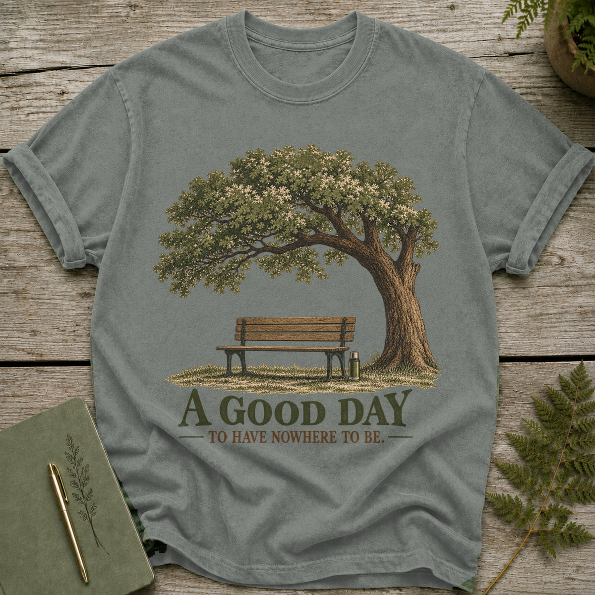 T-shirt with graphic of tree, bench, and thermos, reading "A GOOD DAY TO HAVE NOWHERE TO BE."