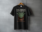 Black t-shirt with "STILL THINKING ABOUT THAT EMAIL TEN YEARS LATER" text and fern design.
