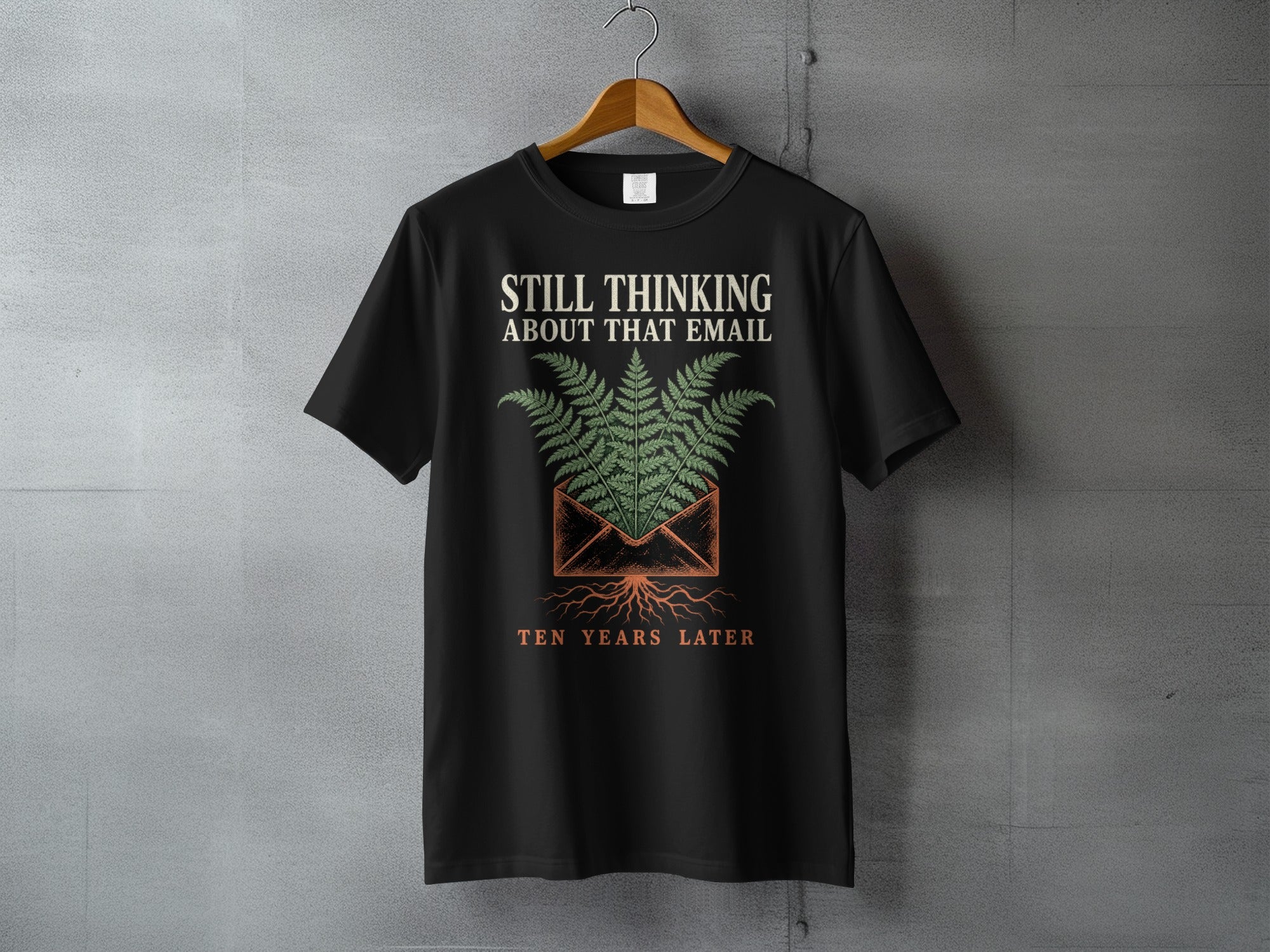 Black t-shirt with "STILL THINKING ABOUT THAT EMAIL TEN YEARS LATER" text and fern design.